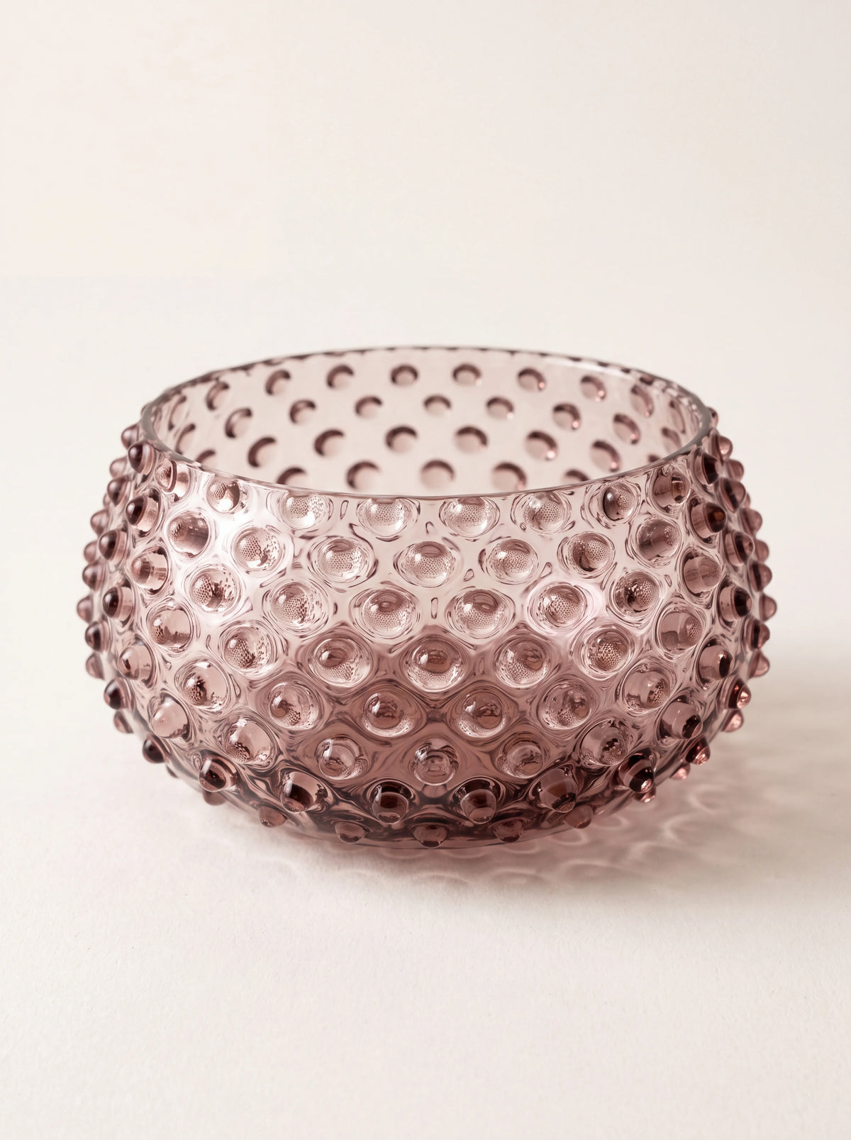 Round amethyst glass bowl with raised hobnail texture and a smooth rim