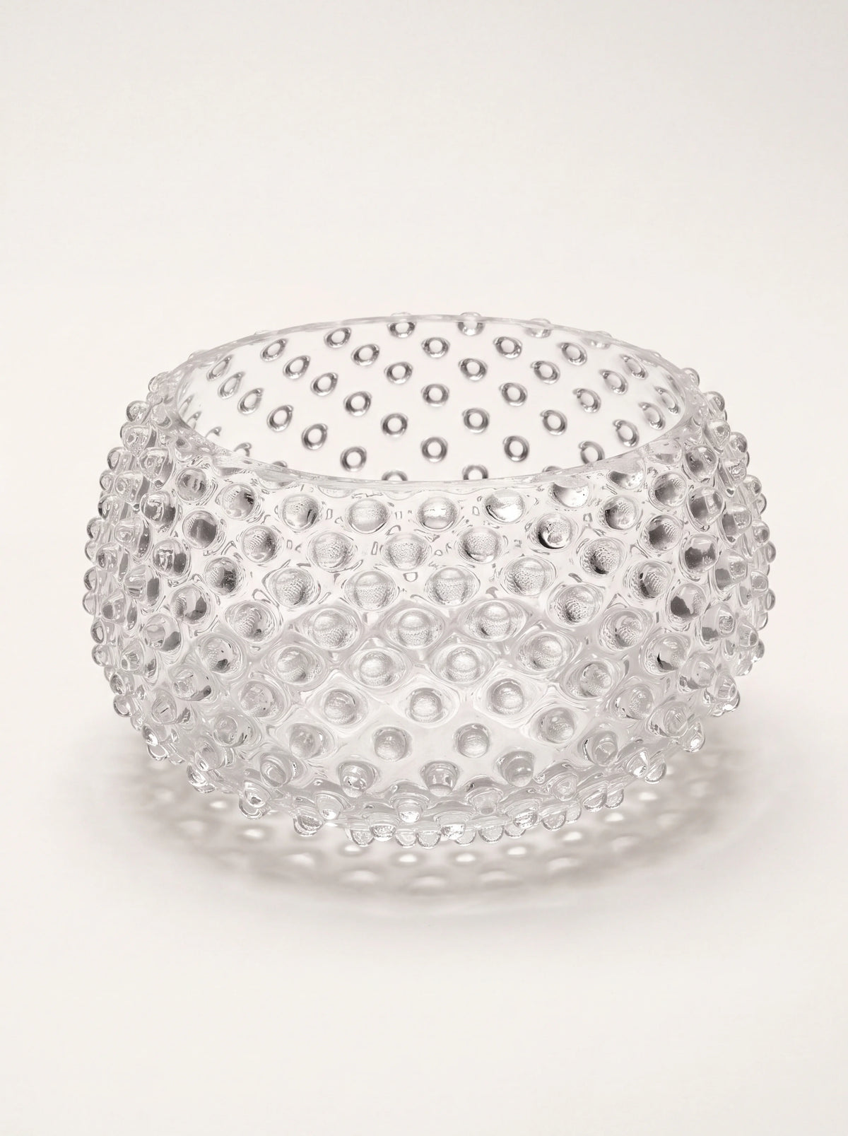 Round clear glass bowl with an all-over raised hobnail texture and inward-curving rim