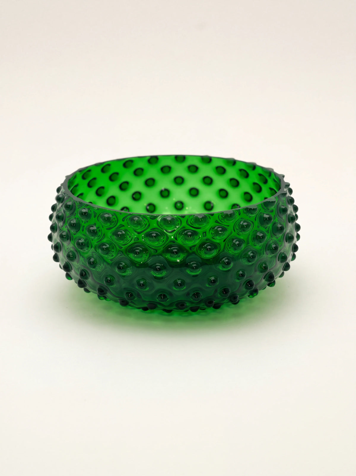 Dark green hand-blown glass bowl with an all-over raised hobnail texture and flat base