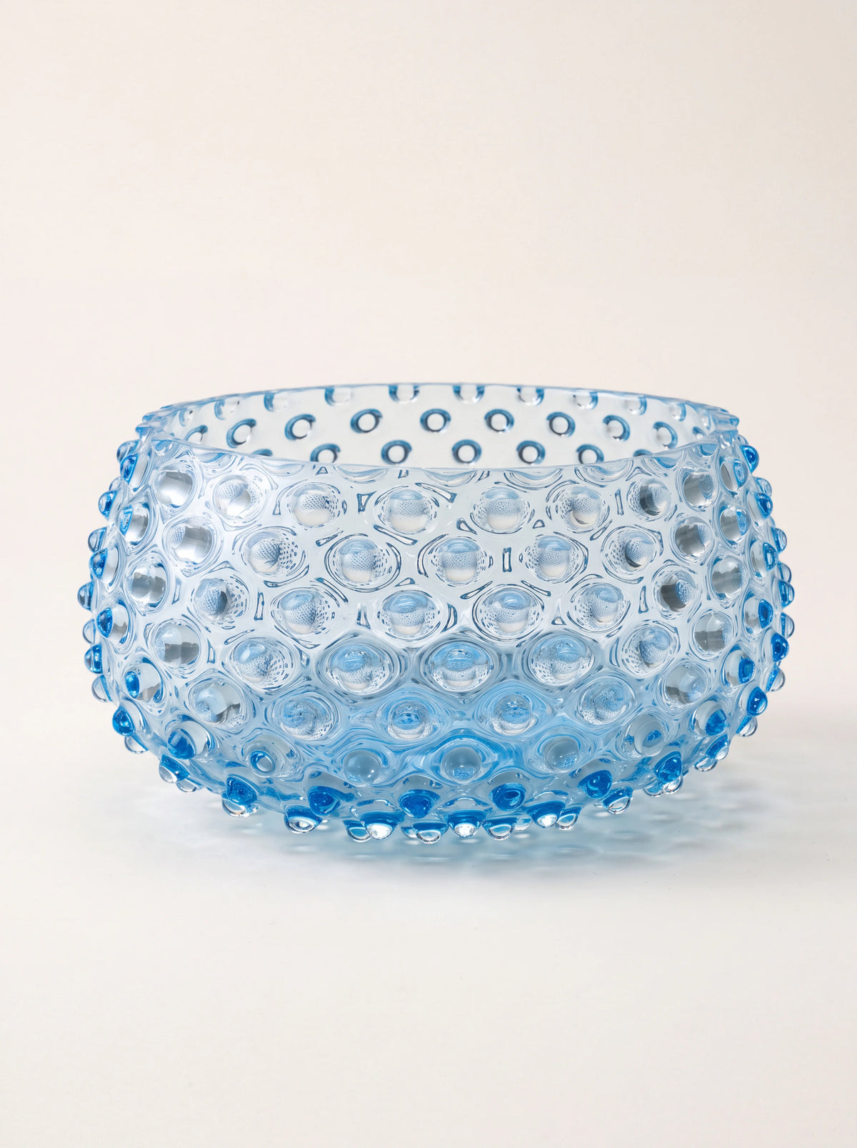 Round light aquamarine glass bowl with a raised hobnail texture and smooth rim