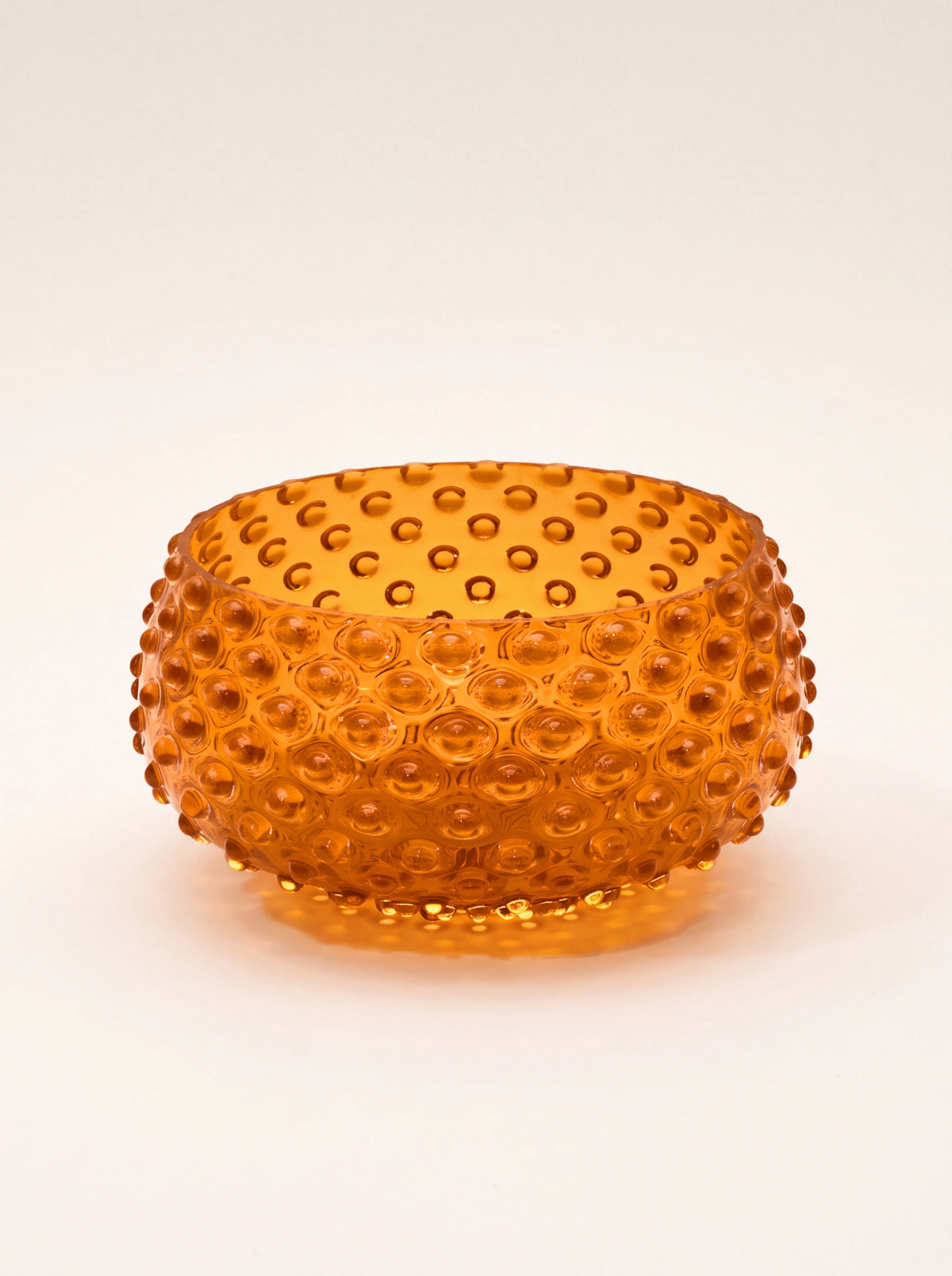 Orange hand-blown glass bowl with an all-over raised hobnail pattern