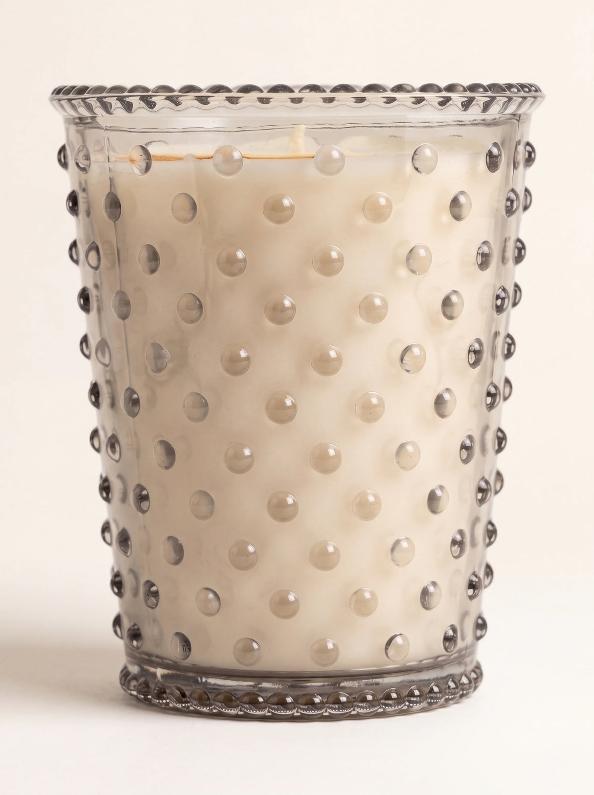 Soy and vegetable wax candle in a hobnail glass vessel with a beaded rim