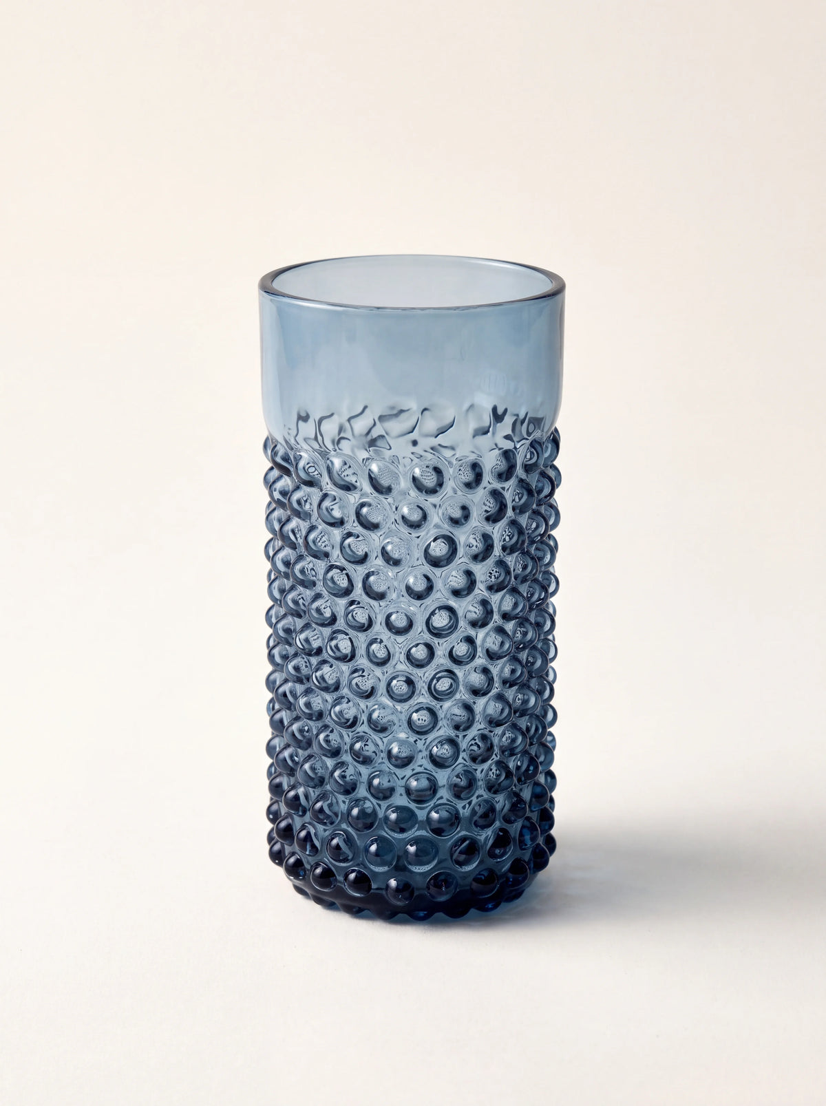 Blue smoke glass tumbler with raised hobnail texture and a smooth rim