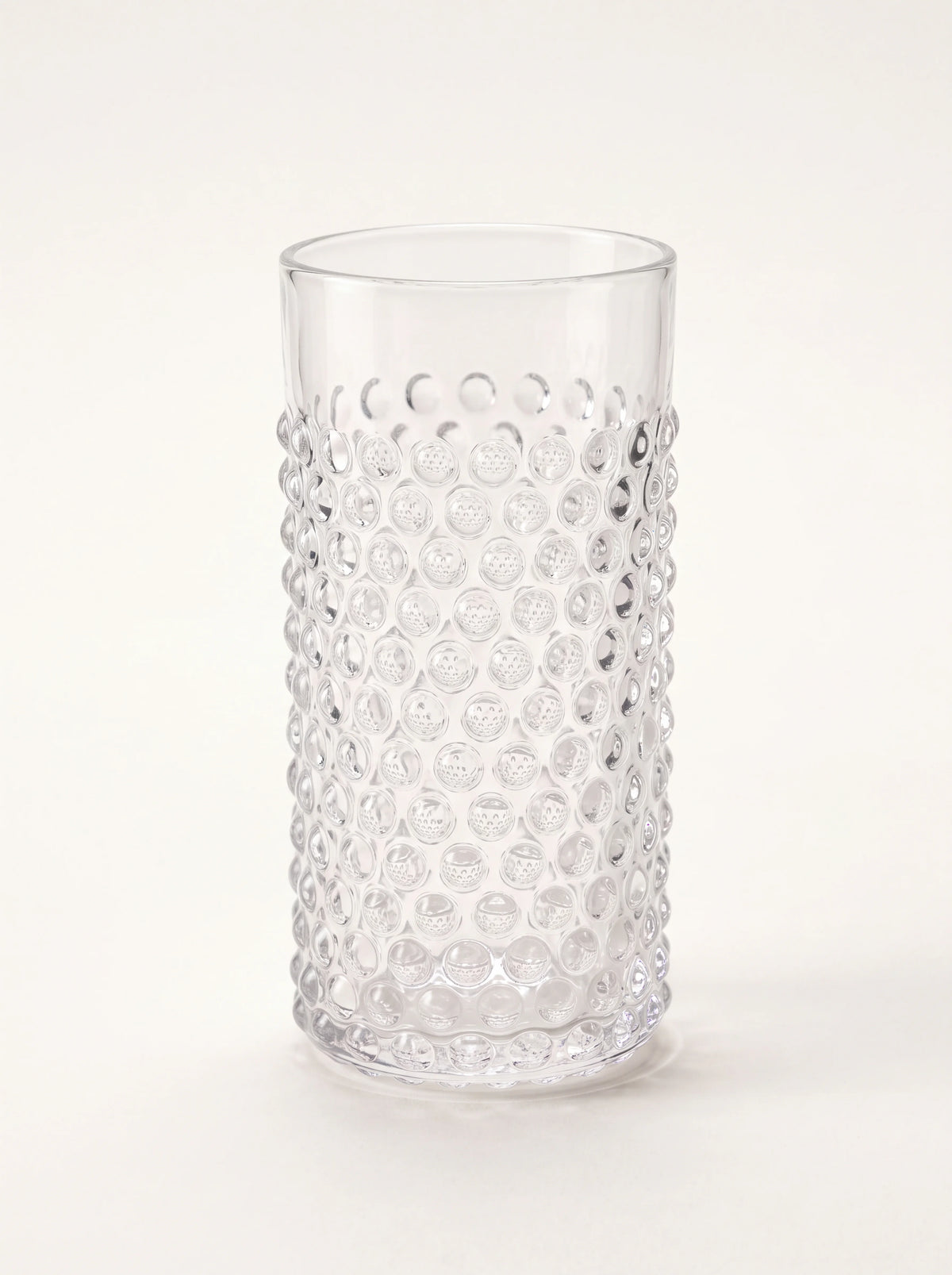 Clear glass tumbler with an all-over raised hobnail pattern and smooth upper rim