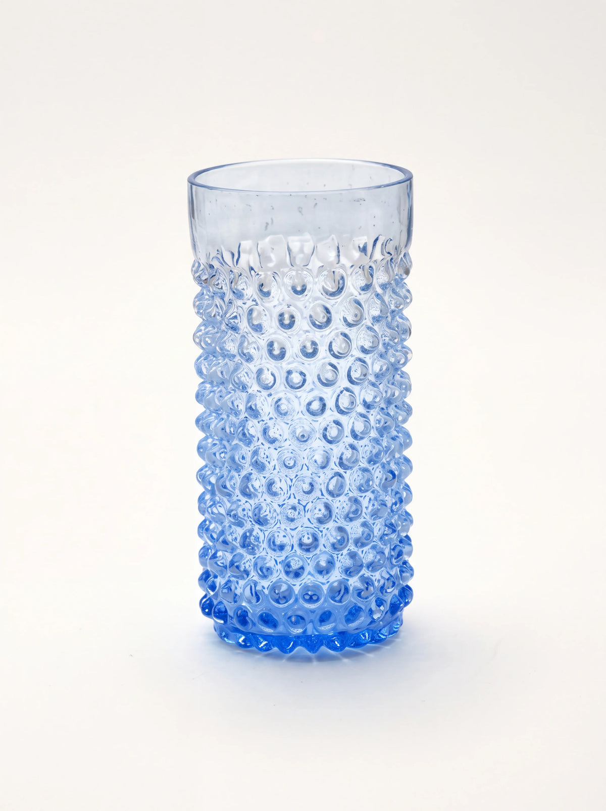 Light blue hobnail glass tumbler with a textured cylindrical body and smooth rim