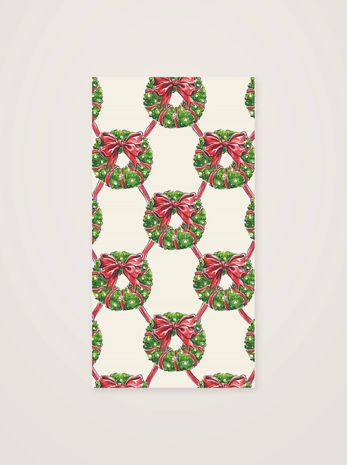Rectangular paper guest napkin featuring a pattern of green foliage wreaths and red ribbon bows