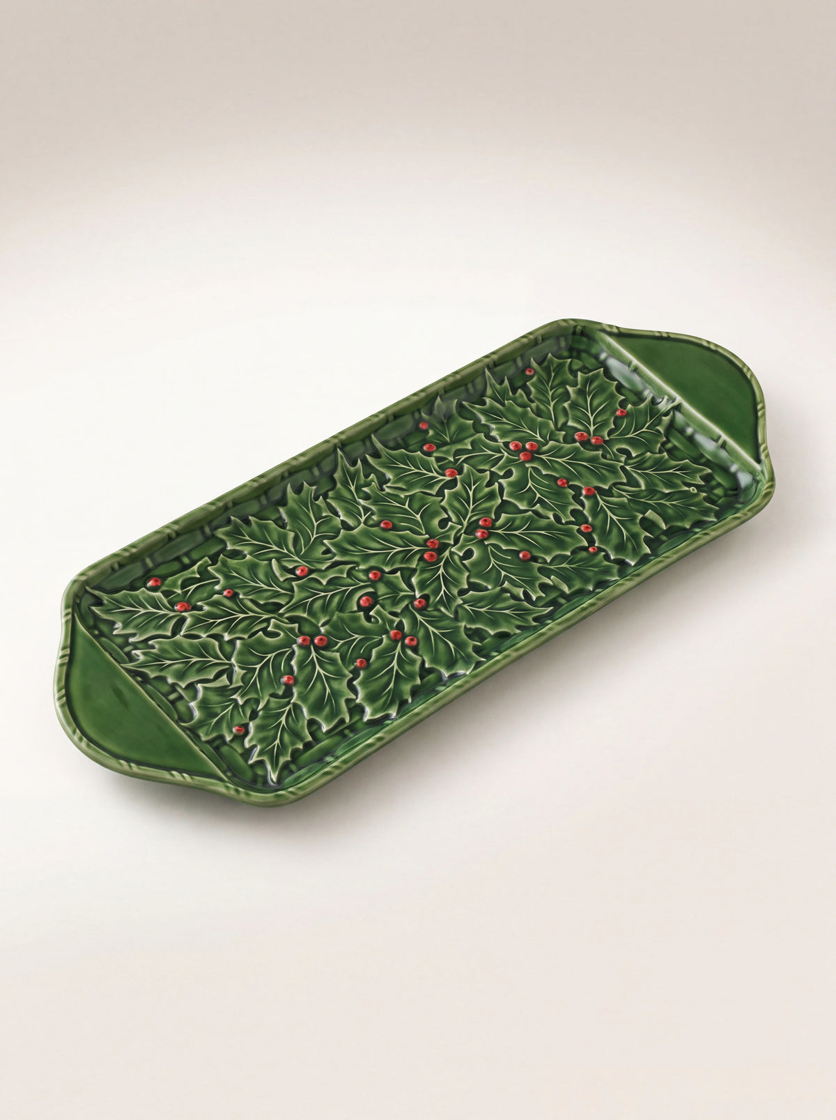Rectangular green glazed earthenware tart tray with relief holly leaves, red berries and side handles