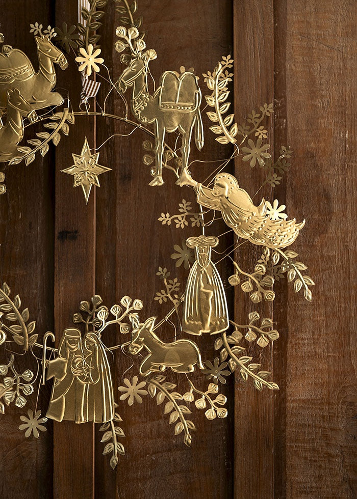 Close-up of the stamped golden metal figures showing details of the Holy Family, donkey, and angel