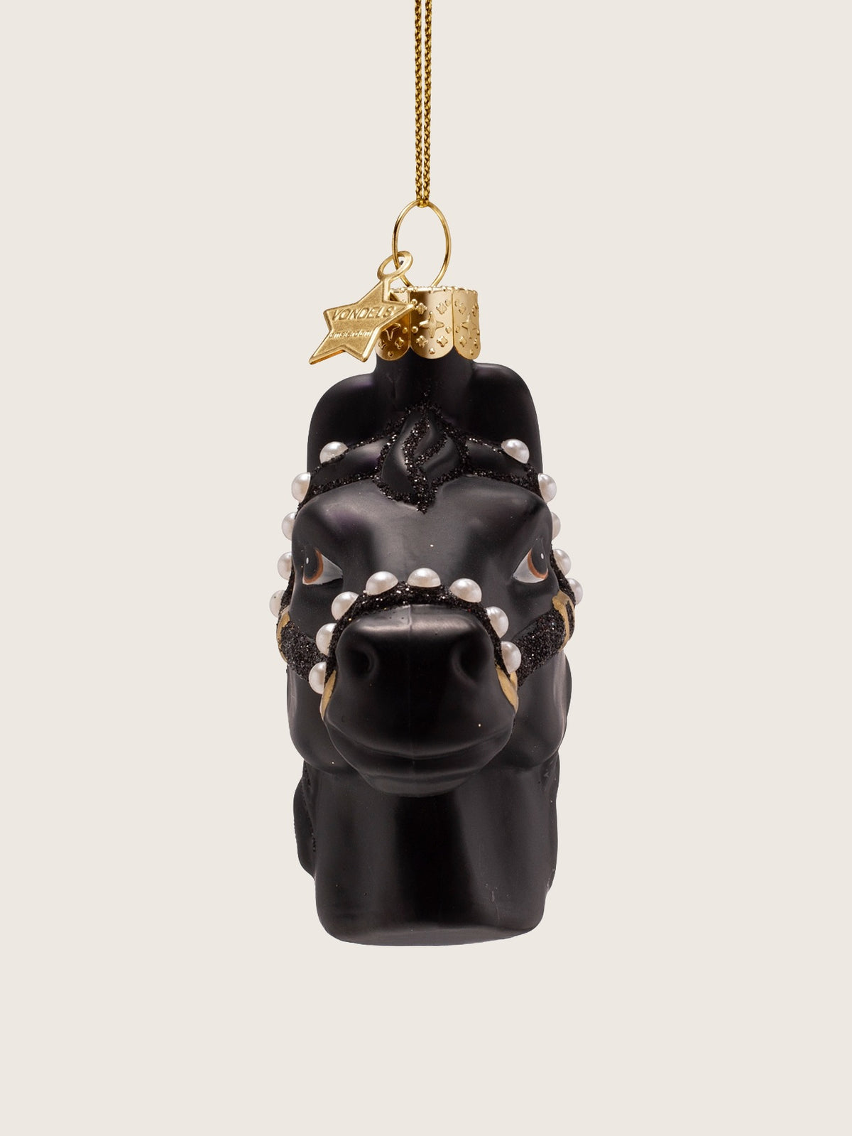 Horse head ornament seen from the front, displaying the symmetrical pearl-studded noseband and forelock