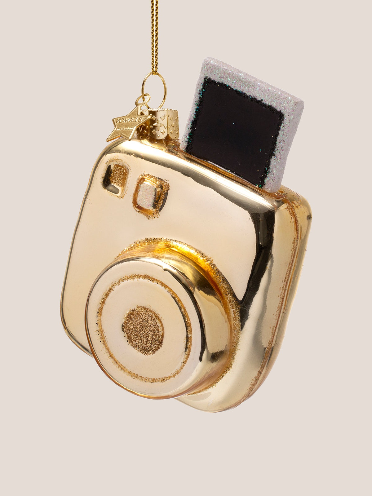 Front-facing three-quarter view showing the circular lens with glitter rings and viewfinder