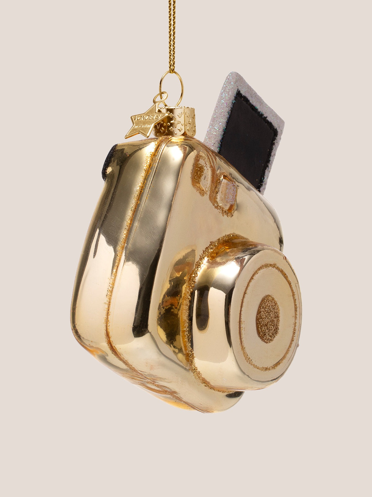 Side view showing the depth of the camera body, gold hanging cord and small star charm