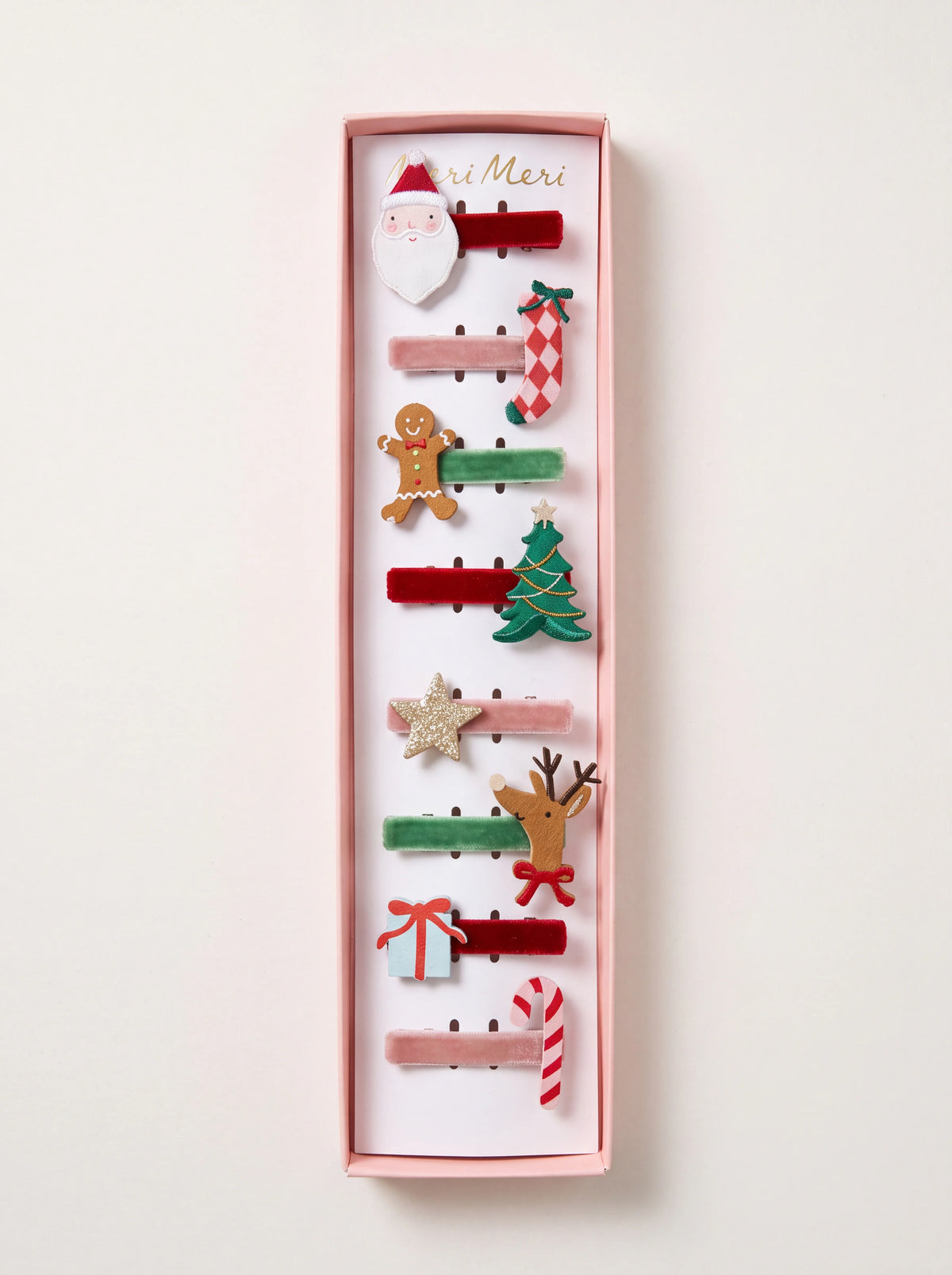 Set of eight Christmas hair clips with festive motifs on red, green and dusty pink velvet ribbon in a gift box