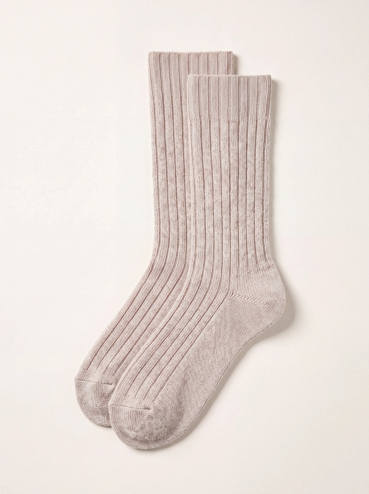 Pair of beige lambswool socks with ribbed texture and smooth knit heels and toes