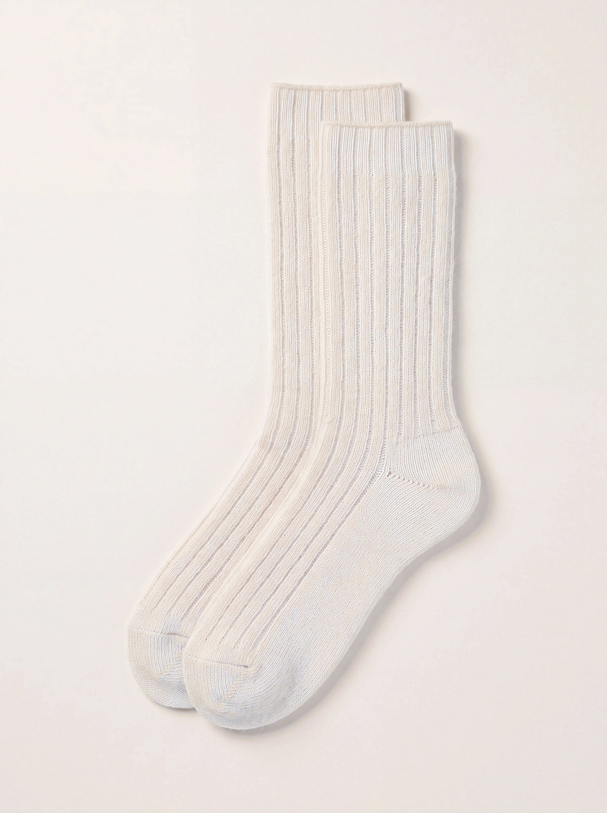 Pair of off-white lambswool socks with a wide ribbed leg and smooth flat-knit sole, heel and toe