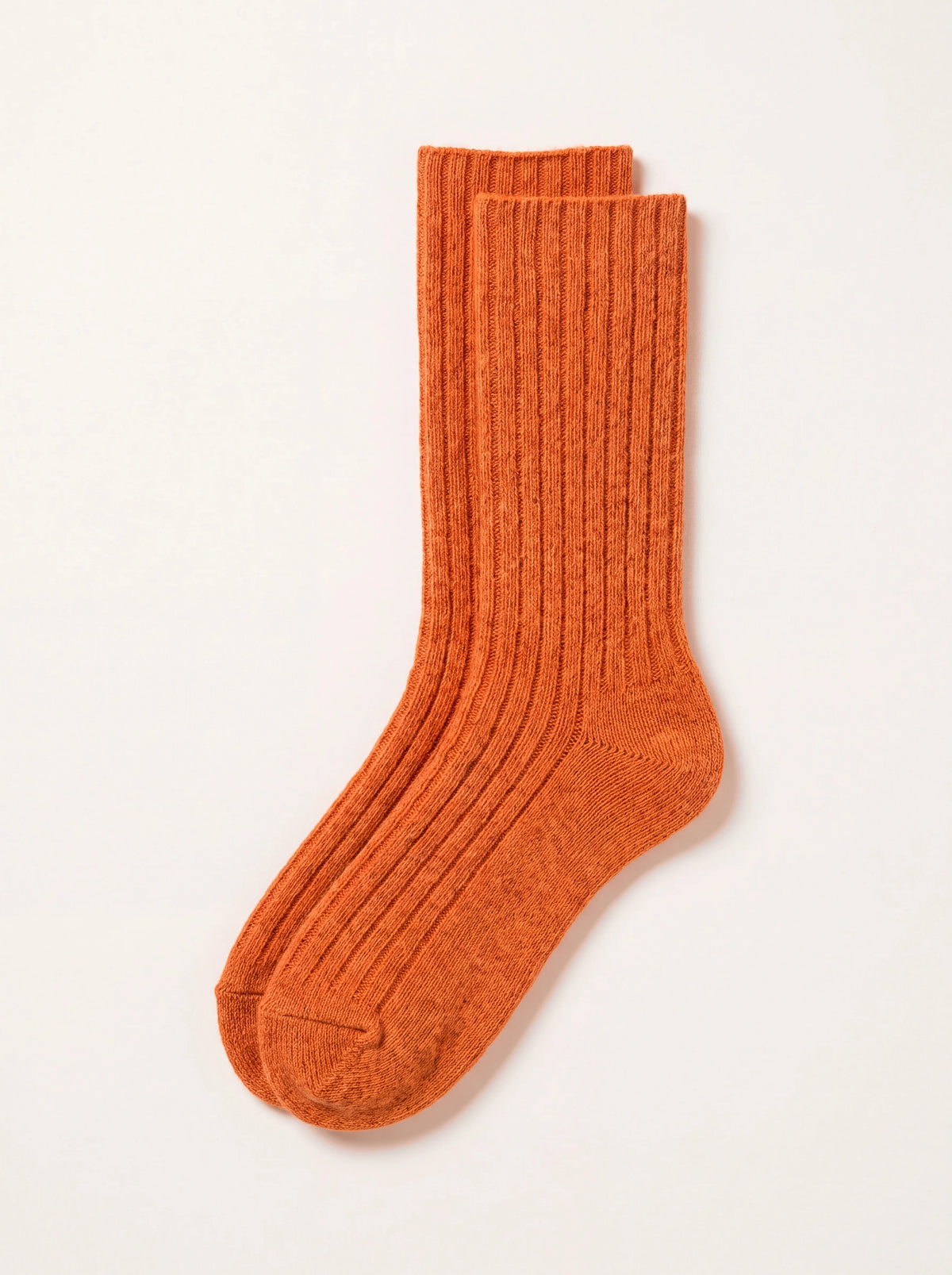 Orange lambswool ribbed socks laid flat, showing the ribbed leg with smooth knit heel and toe