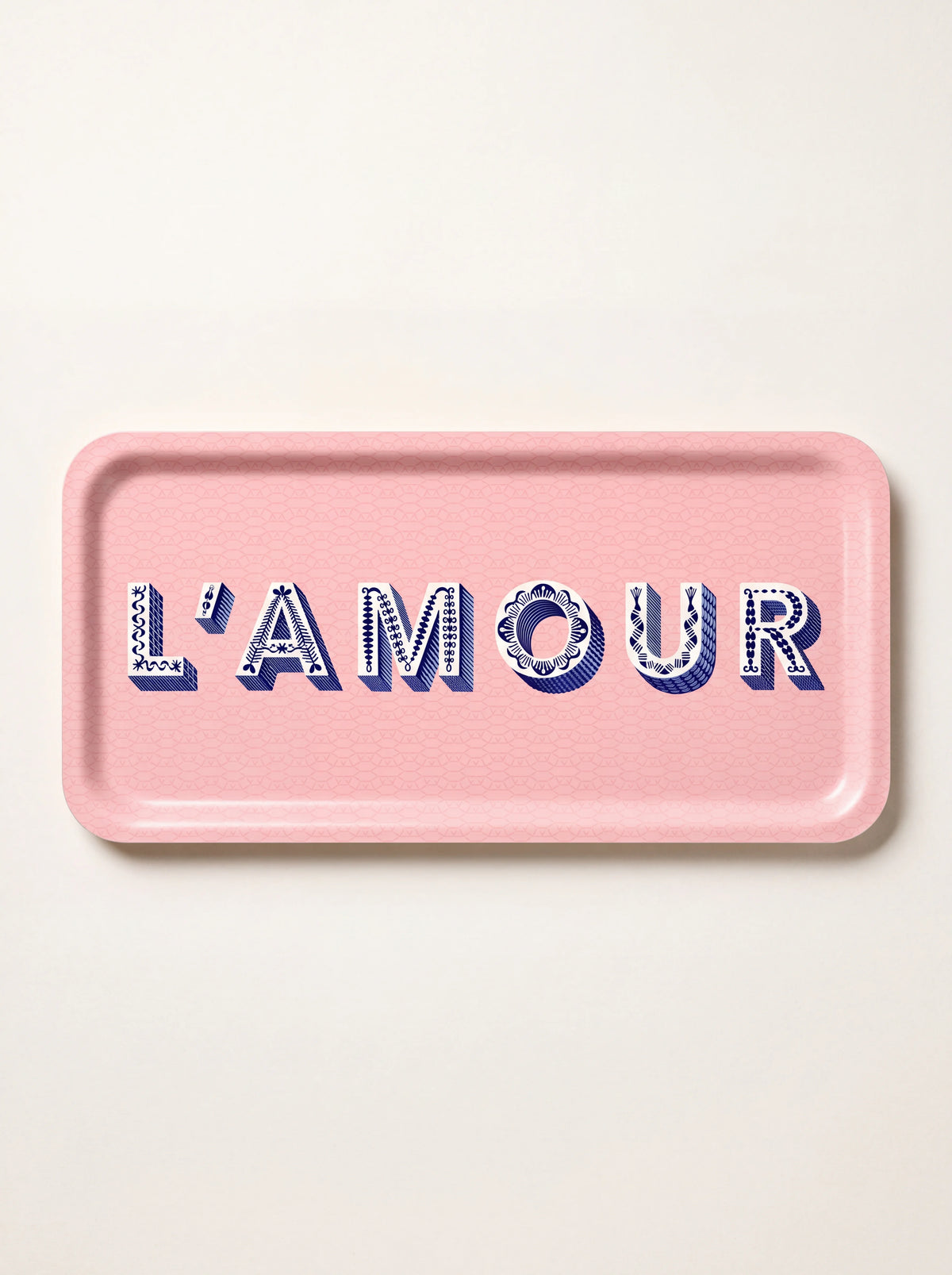 Rectangular light pink birch wood tray with raised rim and decorative blue lettering spelling L'AMOUR