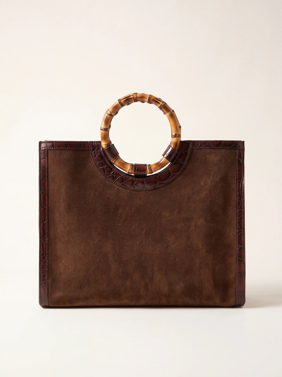 Dark brown suede handbag with a round bamboo handle and crocodile-effect leather trim