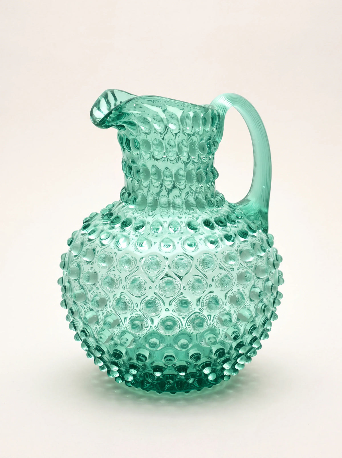 Beryl green hobnail glass jug with a round body, pinched pouring spout and curved handle