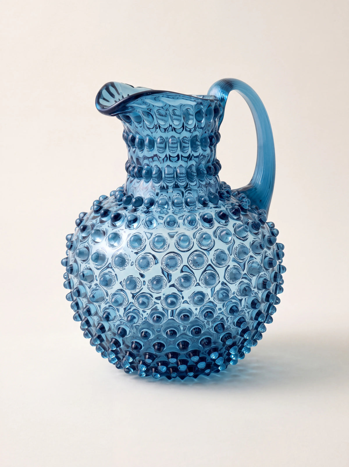 Smoky blue hobnail glass jug with a bulbous body, curved handle and pouring spout