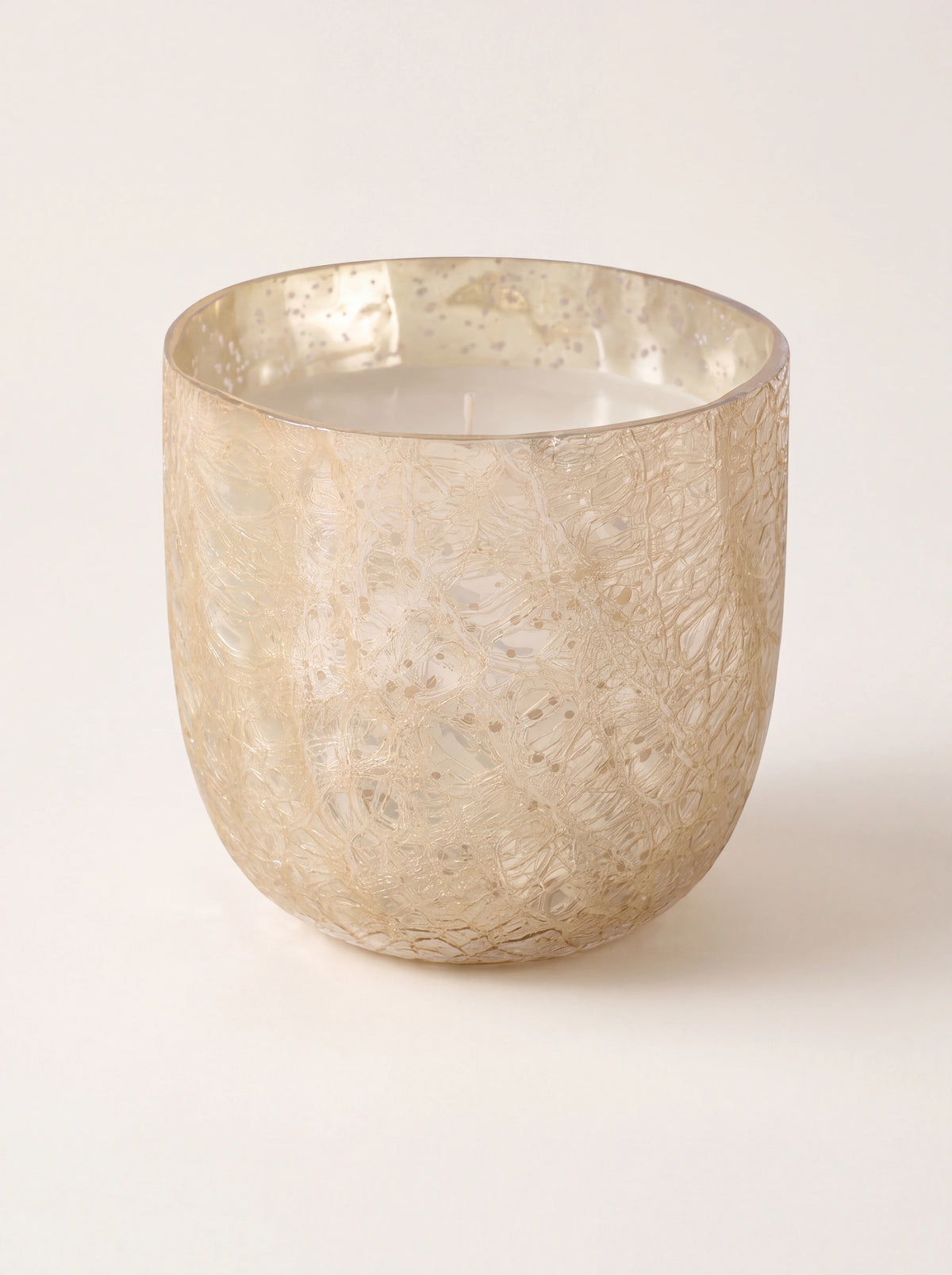 Scented candle with white wax in a cylindrical gold crackle glass vessel