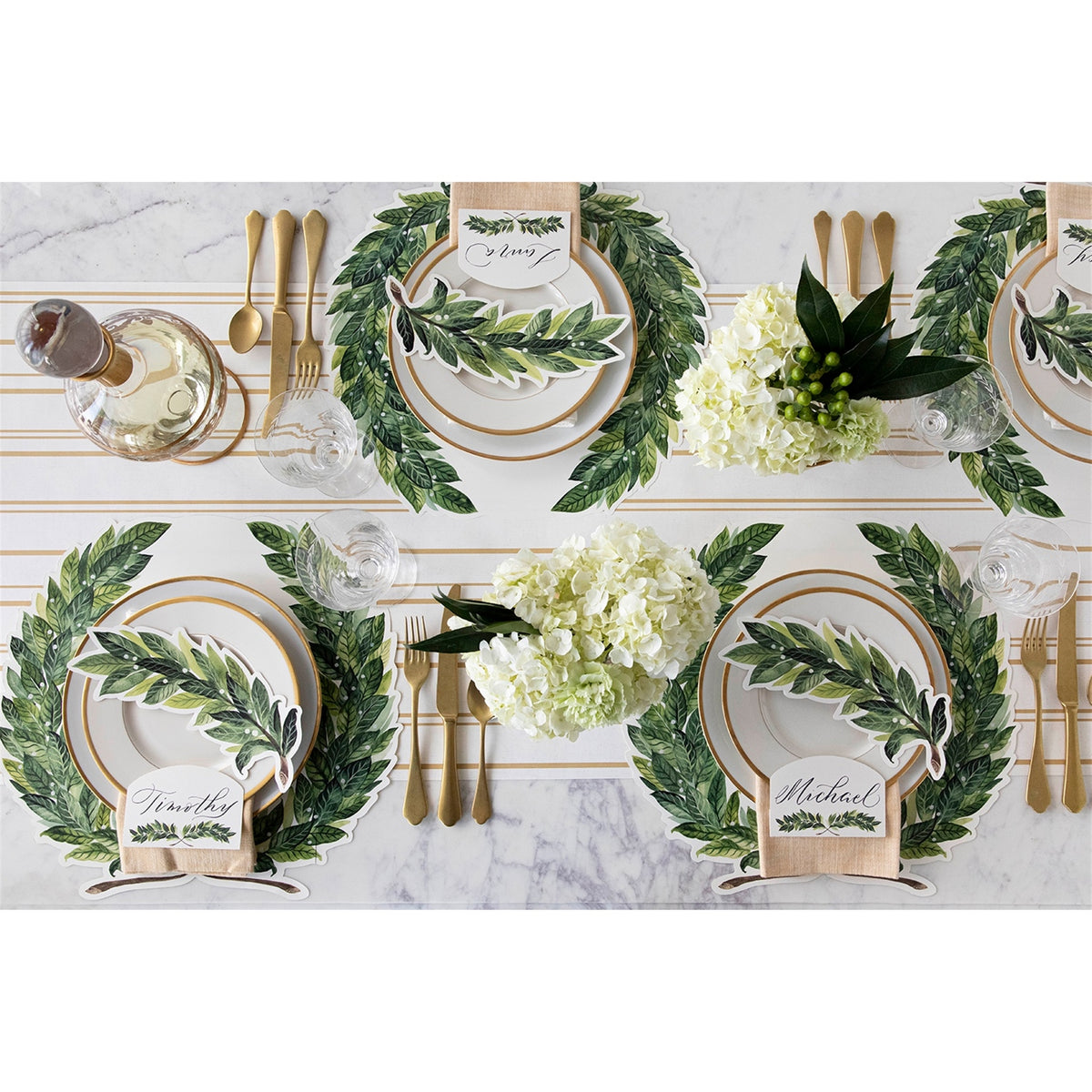 Table set for dining with laurel wreath paper placemats, place cards and floral centrepieces