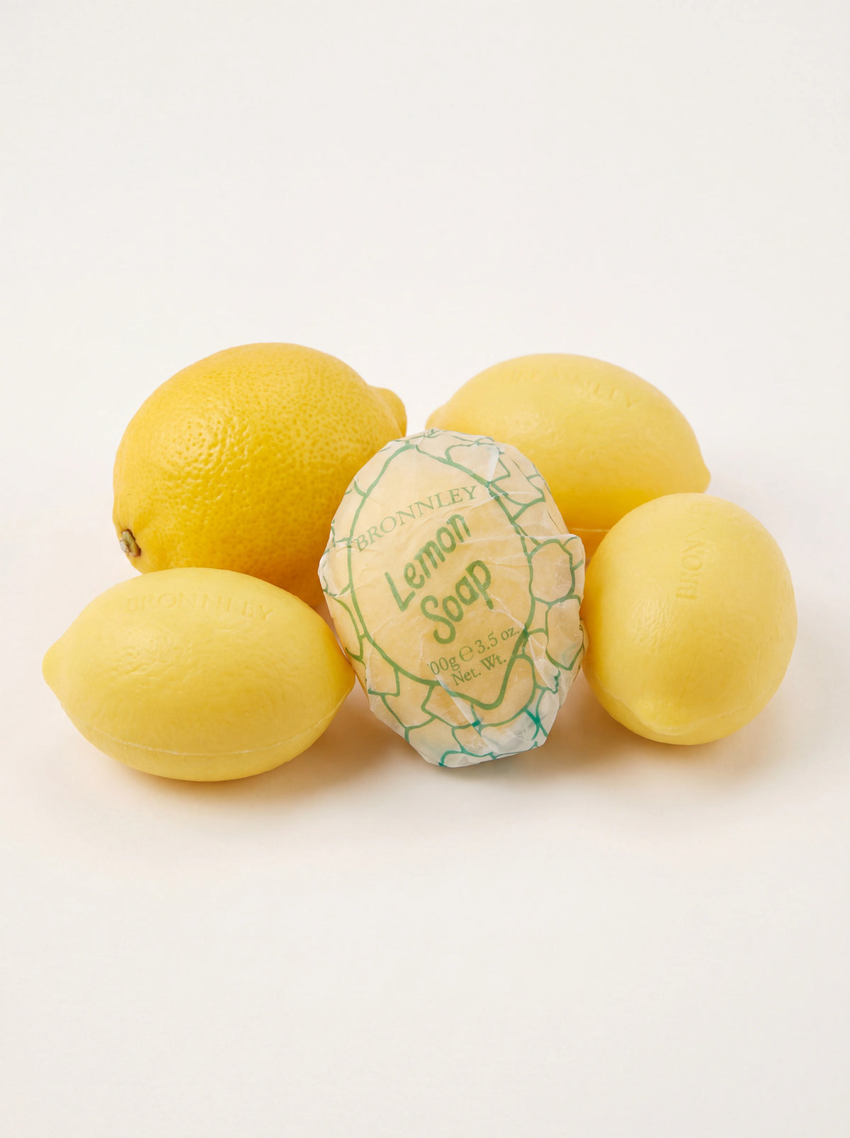Lemon-shaped soaps with textured surfaces, one wrapped in paper reading Lemon Soap