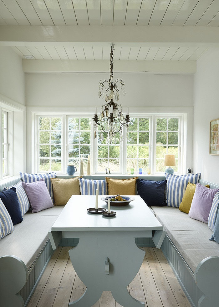 Butternut linen cushions arranged with other cushions on a built-in dining bench