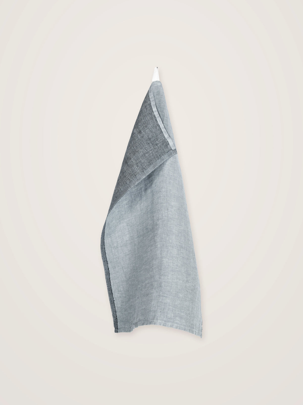 Linen towel hanging by its loop, draped to display the grey and graphite sides