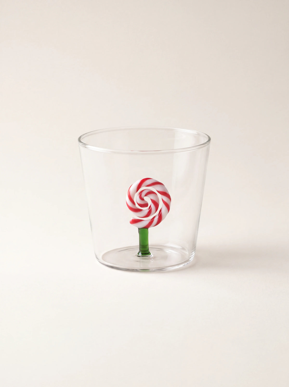 Clear glass tumbler featuring an interior red and white spiral lollipop on a green stem