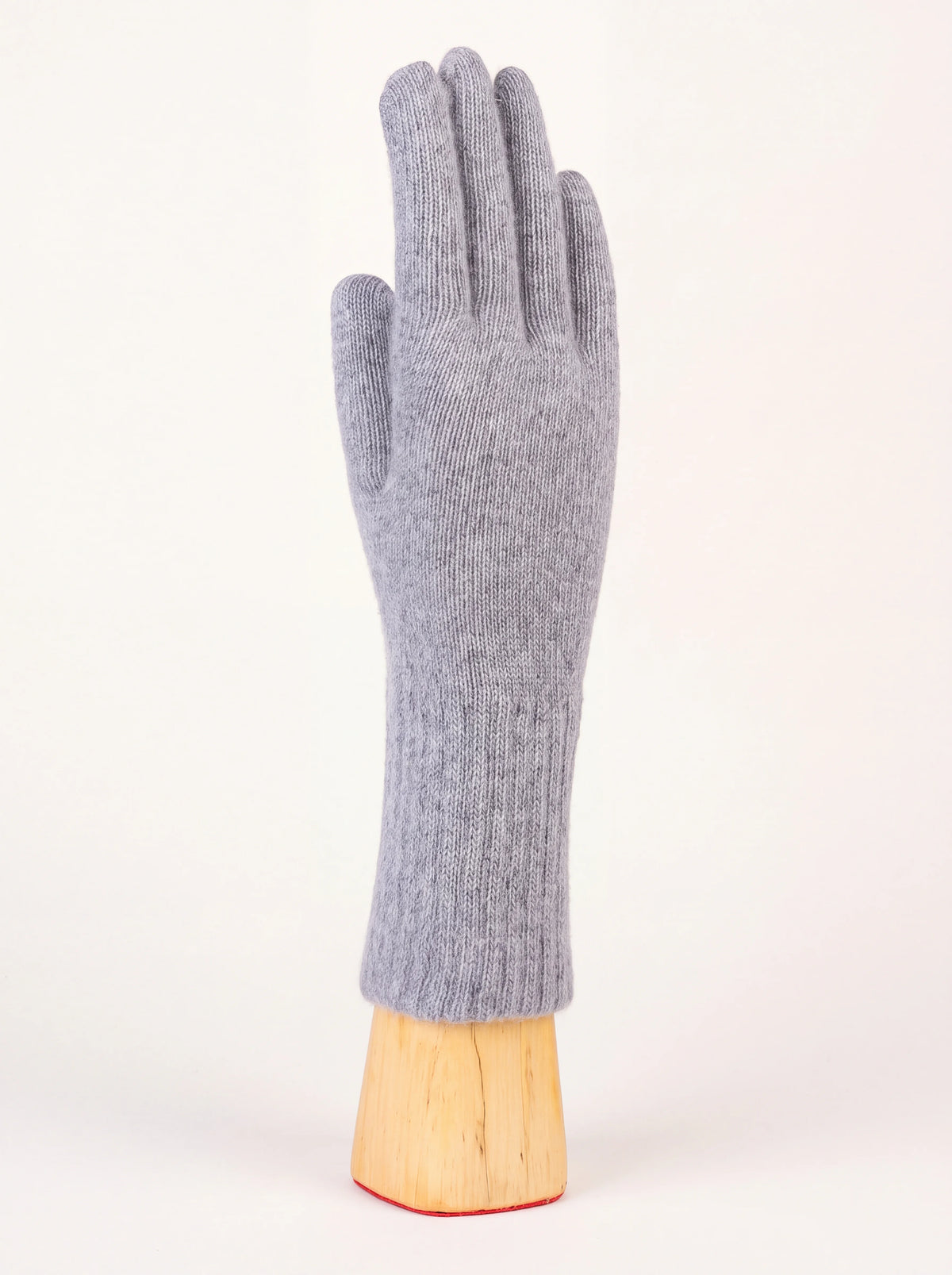 Grey knitted wool and cashmere glove with an elongated cuff, displayed on a wooden stand