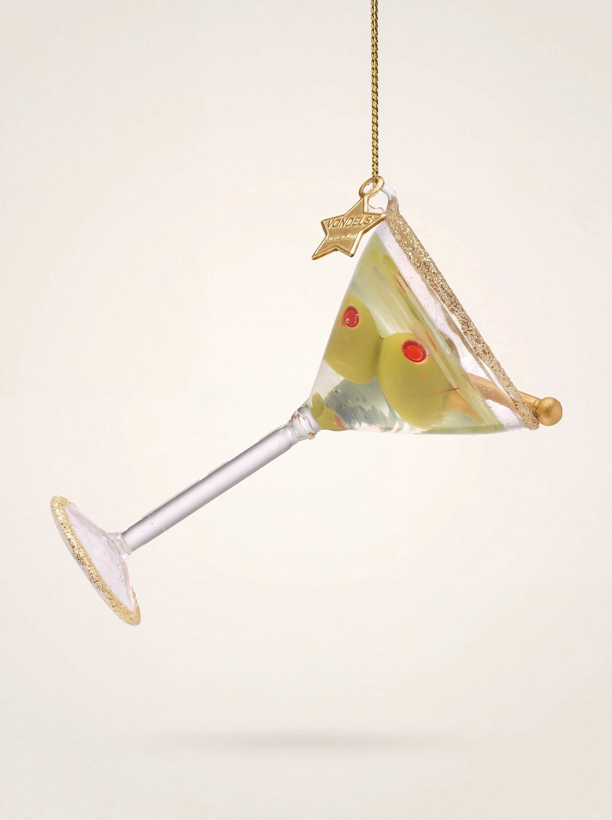 Glass martini cocktail ornament with two skewered olives and gold glitter along the rim and base