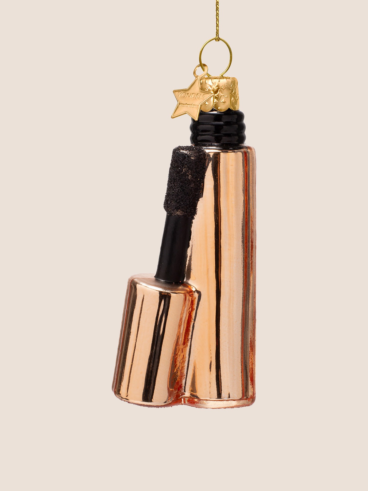 Three-quarter view of the copper mascara ornament highlighting the reflective metallic glass finish