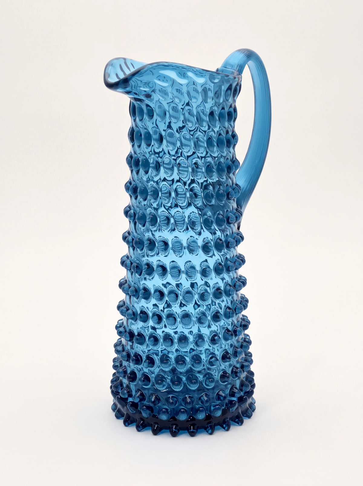 Blue smoke hobnail glass jug with a tapered body, curved handle and pouring spout