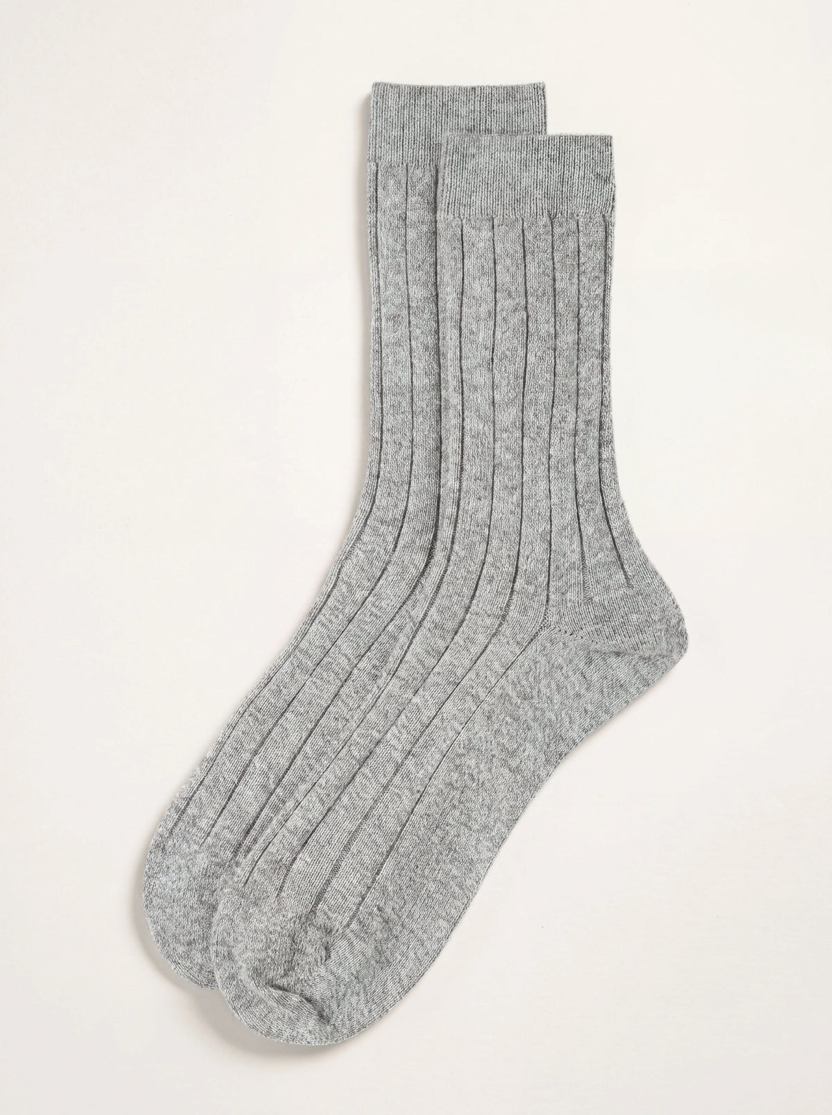 Light grey ribbed cashmere socks laid flat, showing the vertical ribs and smooth heel and toe