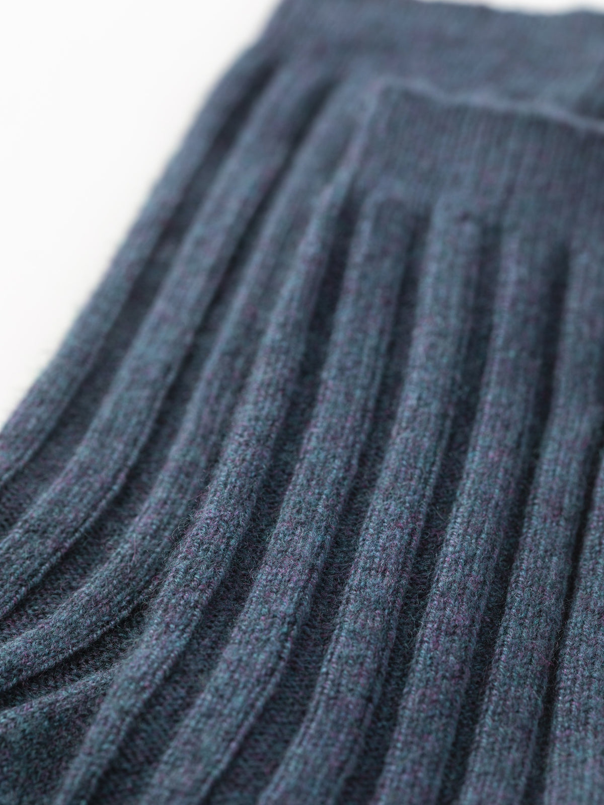 Close-up of the ribbed cashmere knit showing the texture of the heather navy yarn