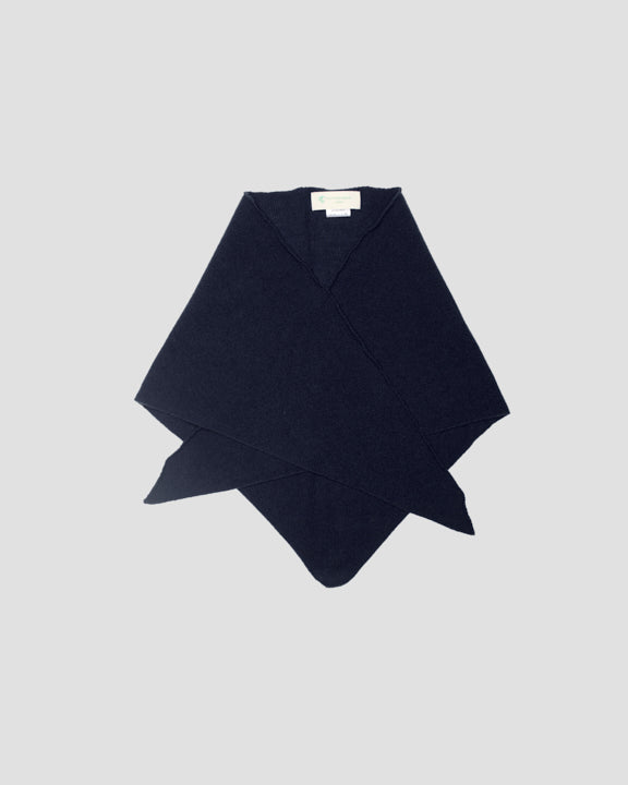 Navy merino wool bandana folded flat with crossed corners, showing the white inner label