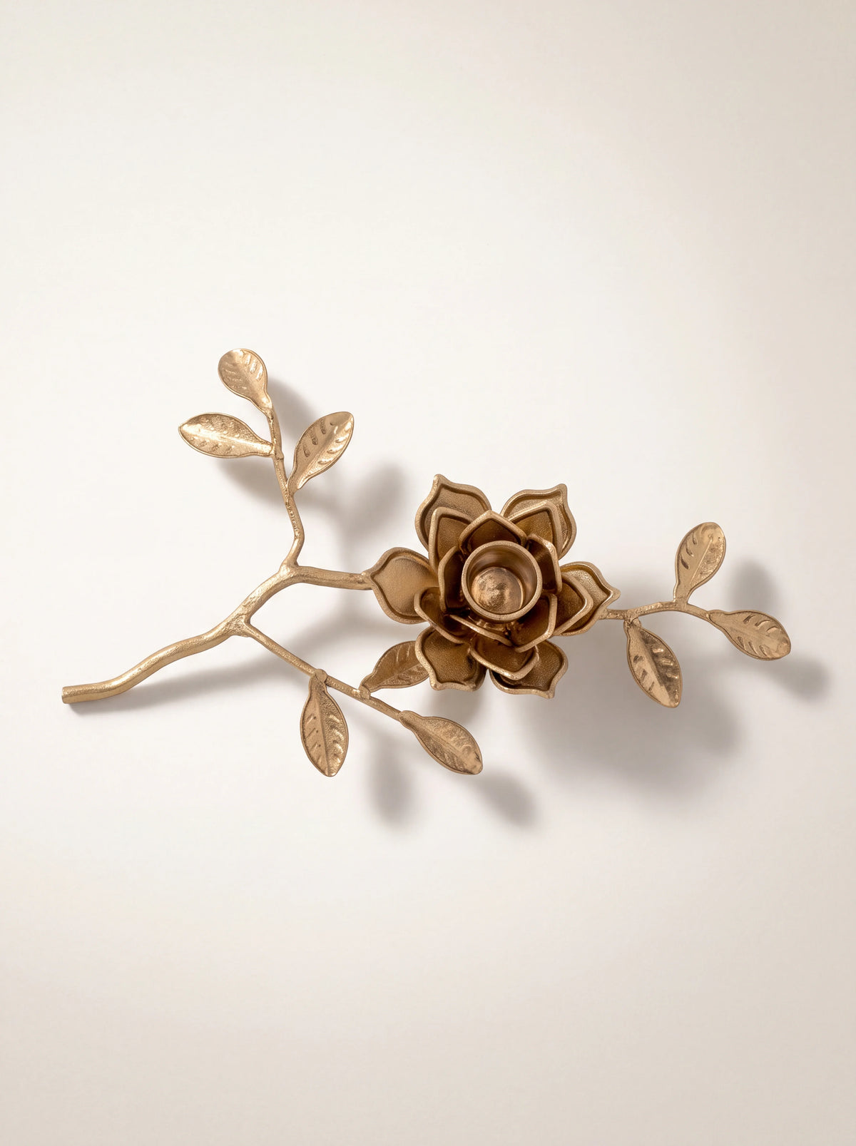 Gold iron branch candle holder from above, showing the layered petals and veined leaves