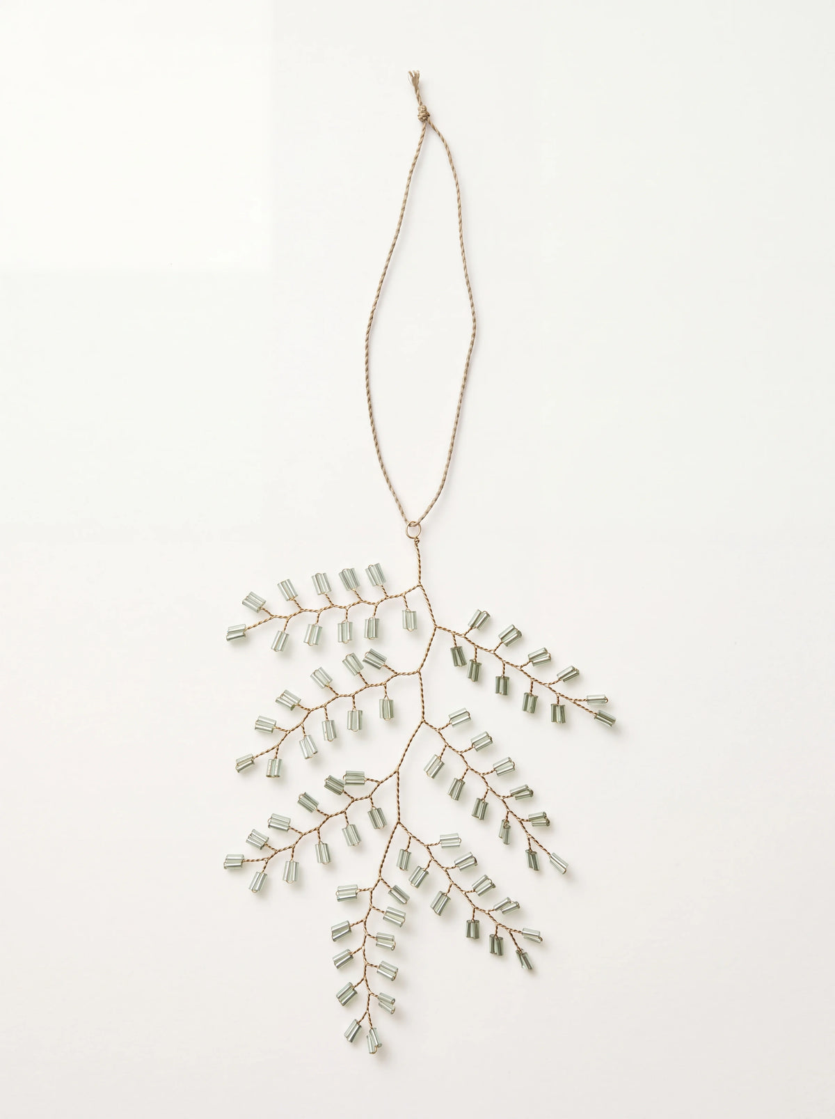 Twig-shaped Christmas ornament made of wire with pale green glass beads and a hanging cord