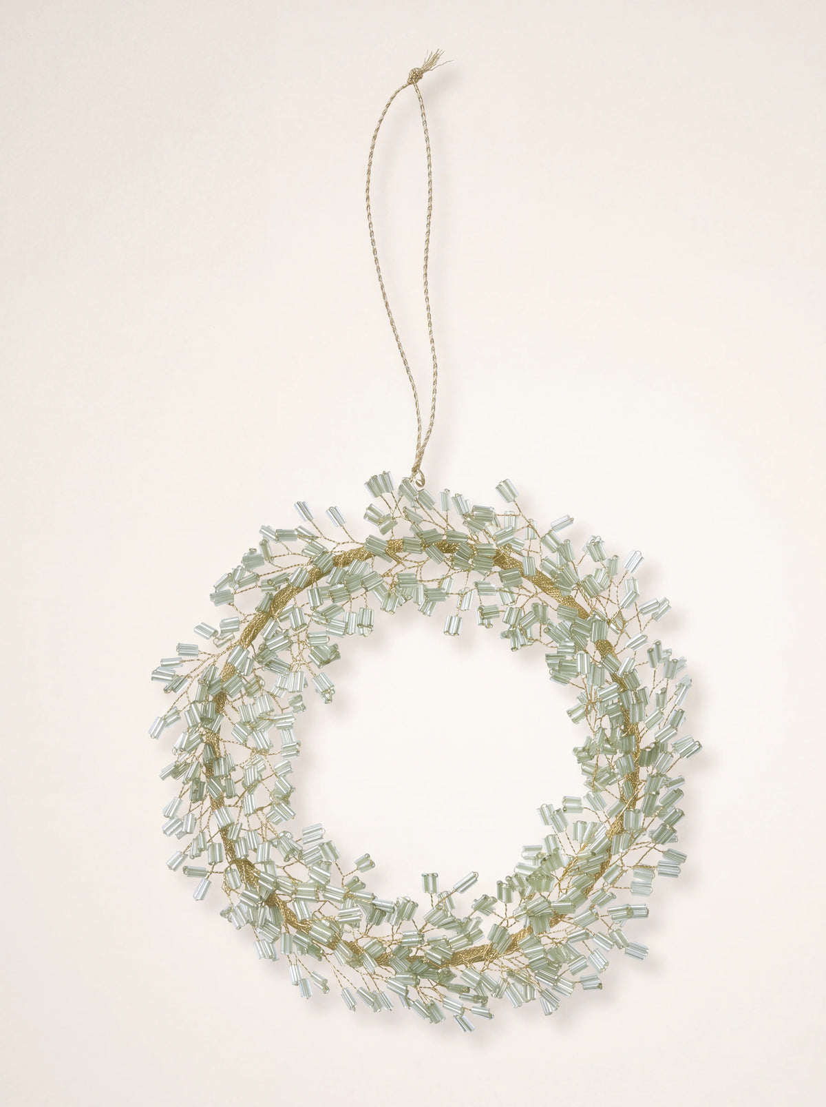 Circular wreath ornament made with pale jade glass beads on gold-tone wire with a hanging loop