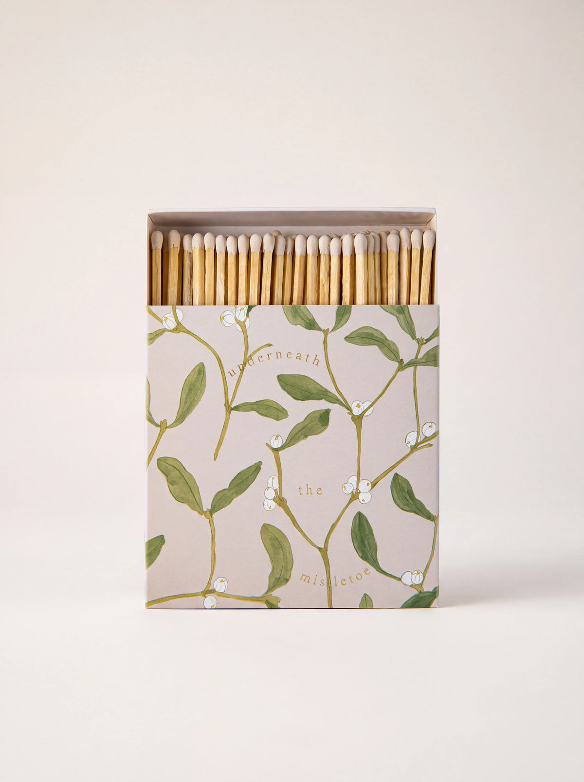 Square matchbox opened to show wooden matches, with mistletoe print reading 'underneath the mistletoe