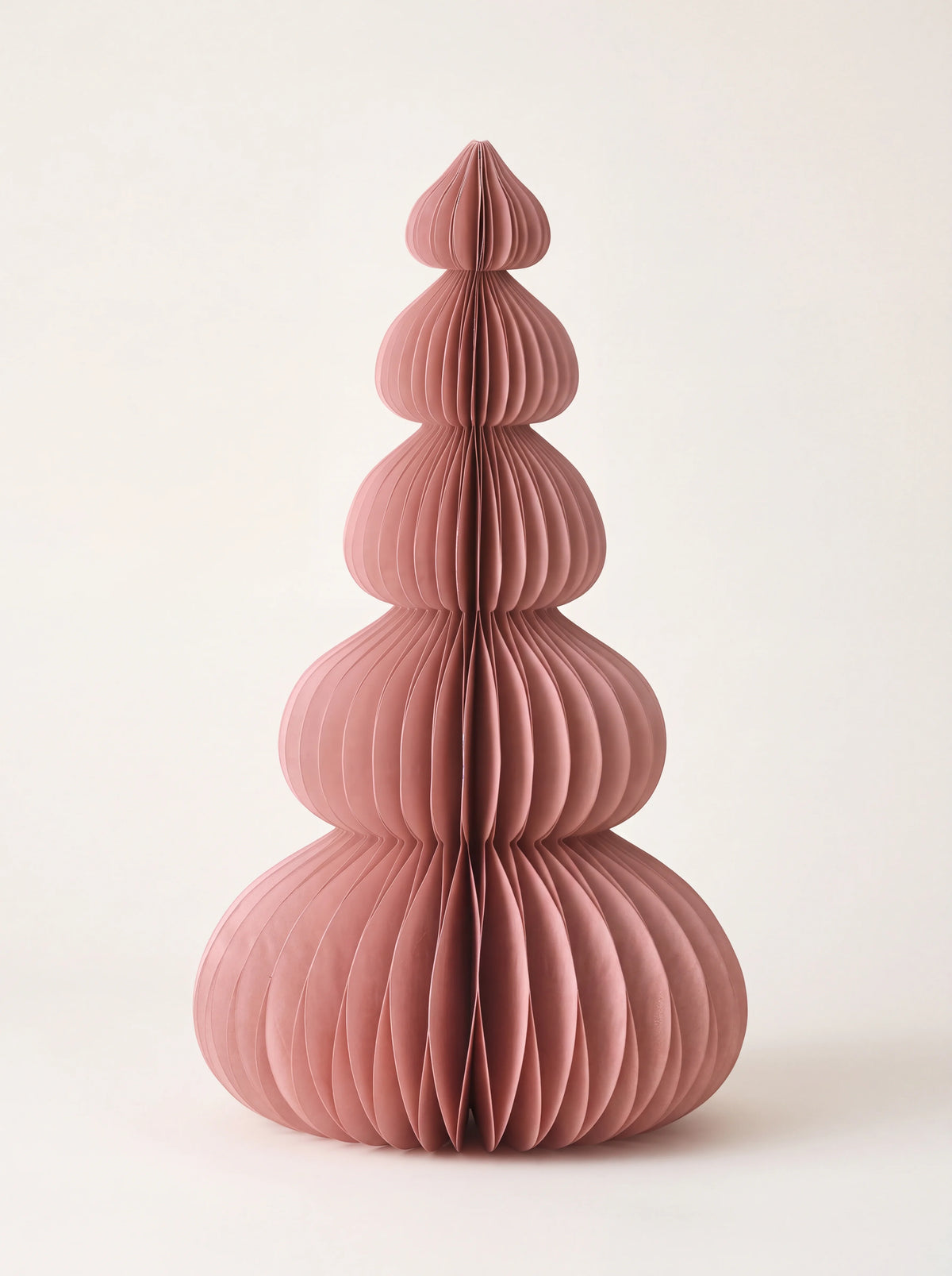Paper honeycomb tree decoration in dusty rose featuring five rounded tiers tapering to a point