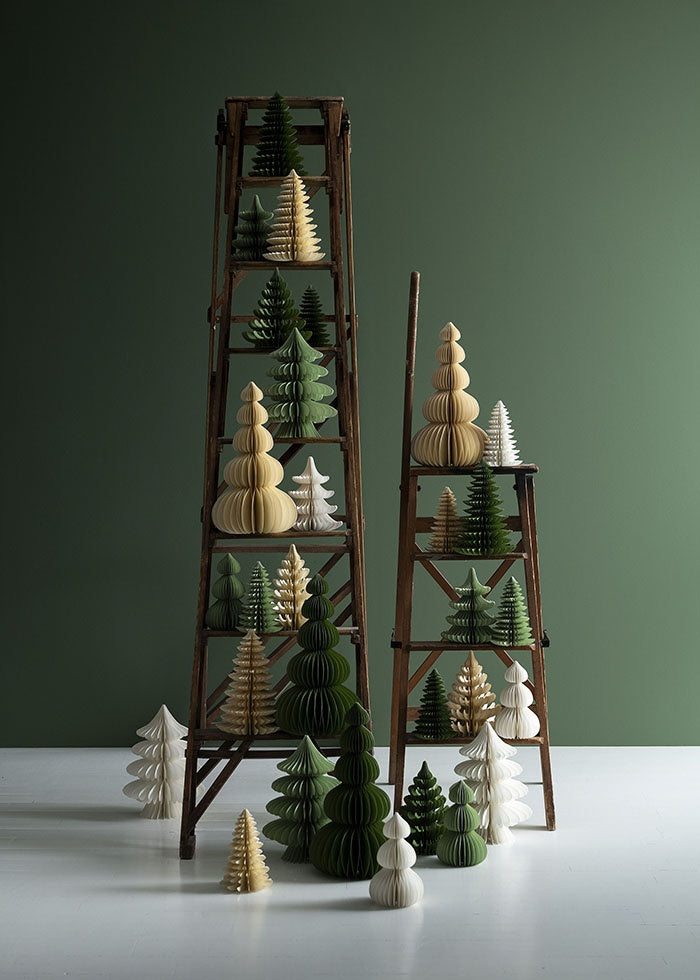 Assorted paper honeycomb trees in various sizes and tones styled across two wooden ladders
