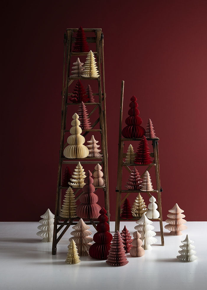 Cream honeycomb tree placed on a wooden stepladder among red and blush paper decorations
