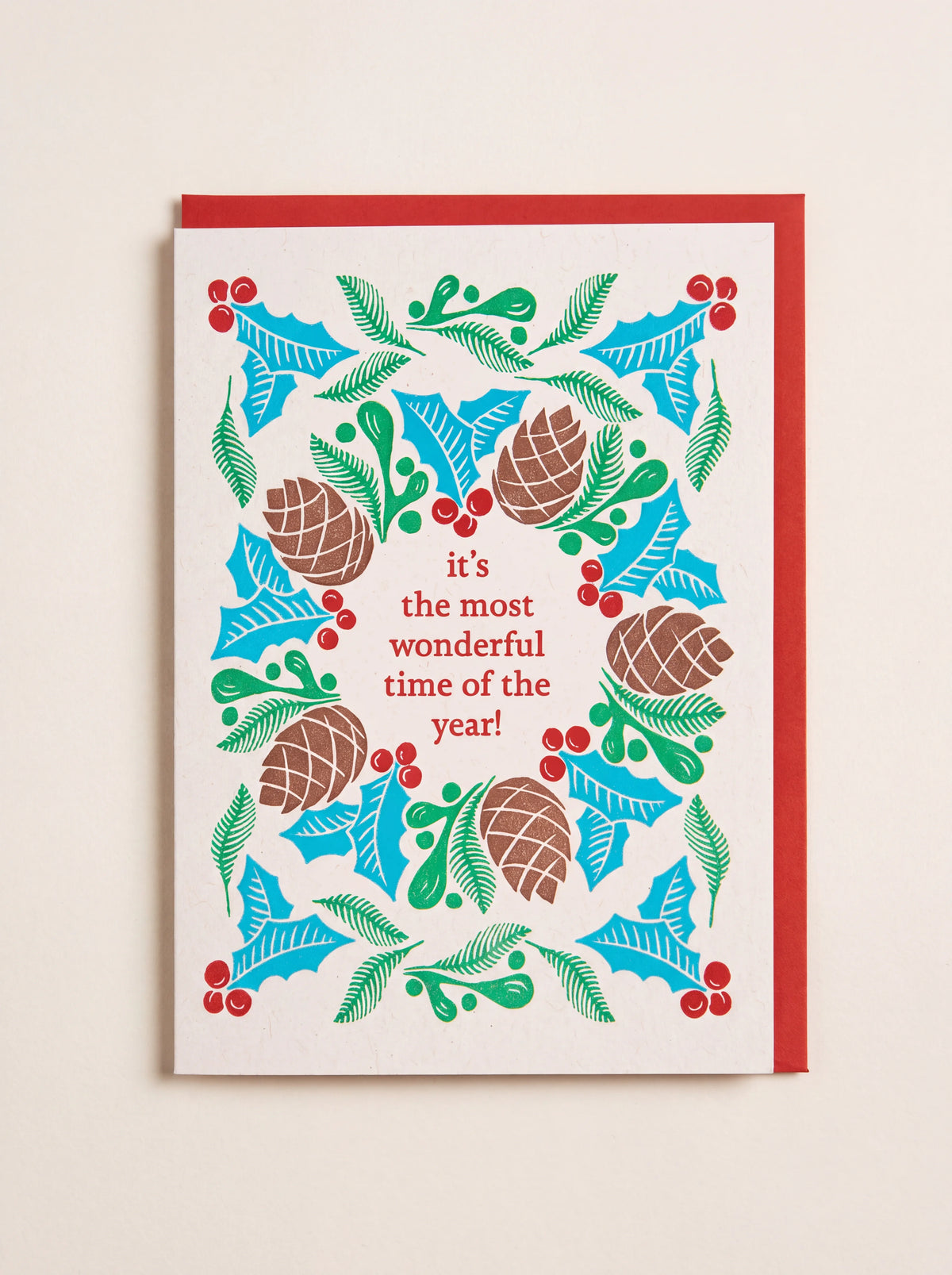 Christmas card reading "it's the most wonderful time of the year!" in a festive wreath, with a red envelope