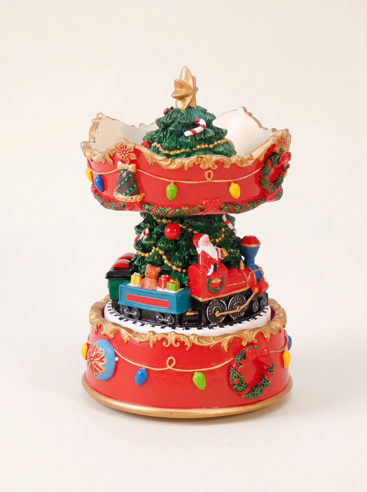 Musical Christmas carousel showing the miniature train with a teddy bear and gifts on the circular track