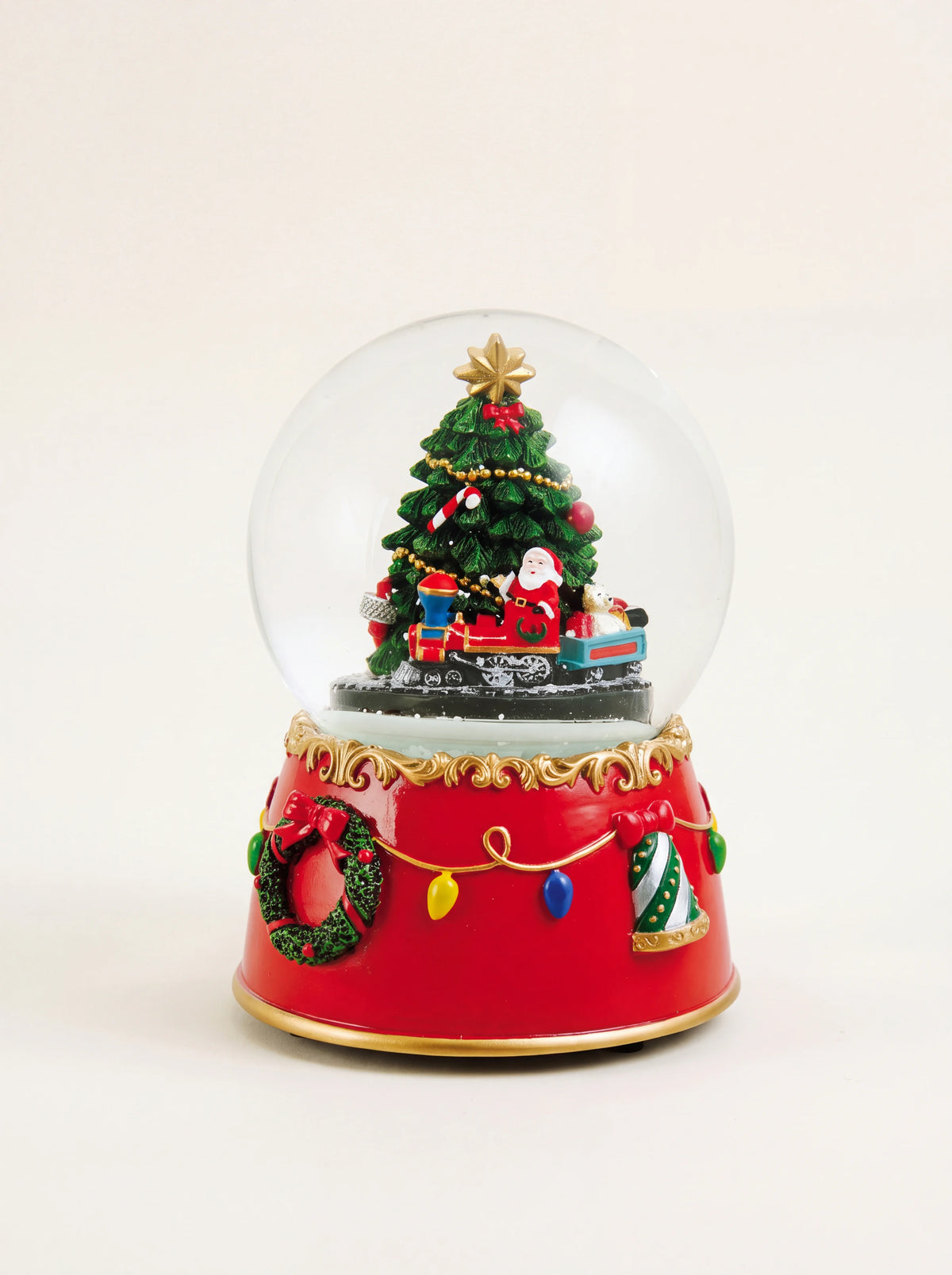 Musical snow globe with a decorated Christmas tree, Santa on a train, and a red base with garland motifs