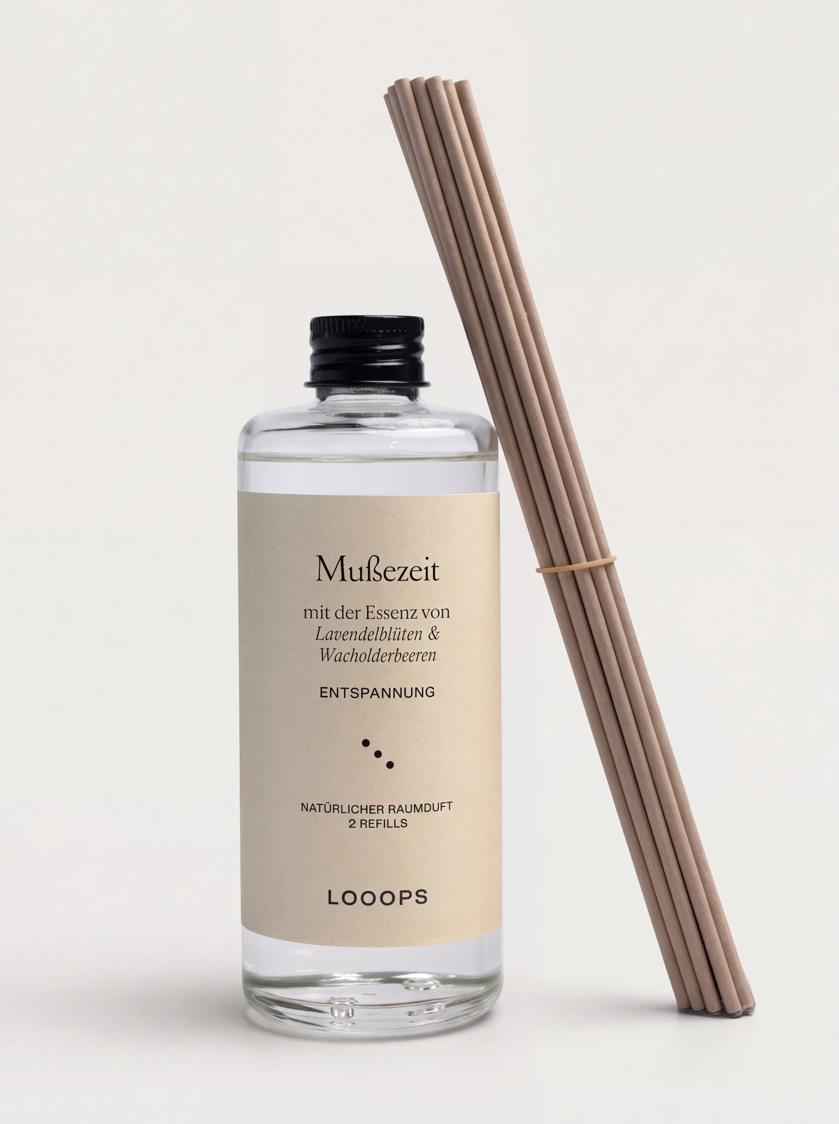 Reed diffuser refill in a clear glass bottle with a beige label, black screw cap and a bundle of paper reeds