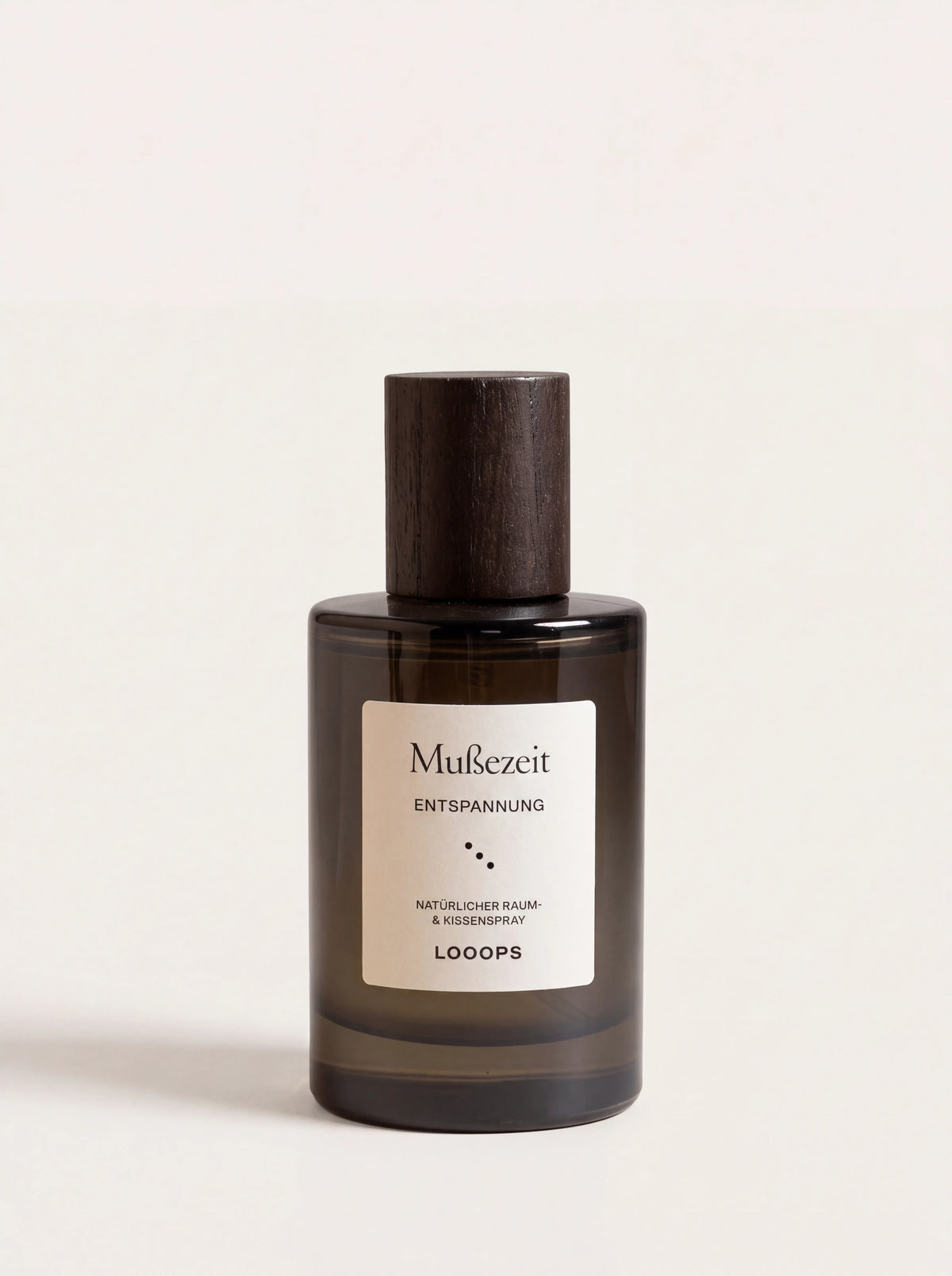 Mußezeit room spray in a cylindrical dark glass bottle with a dark wooden cap