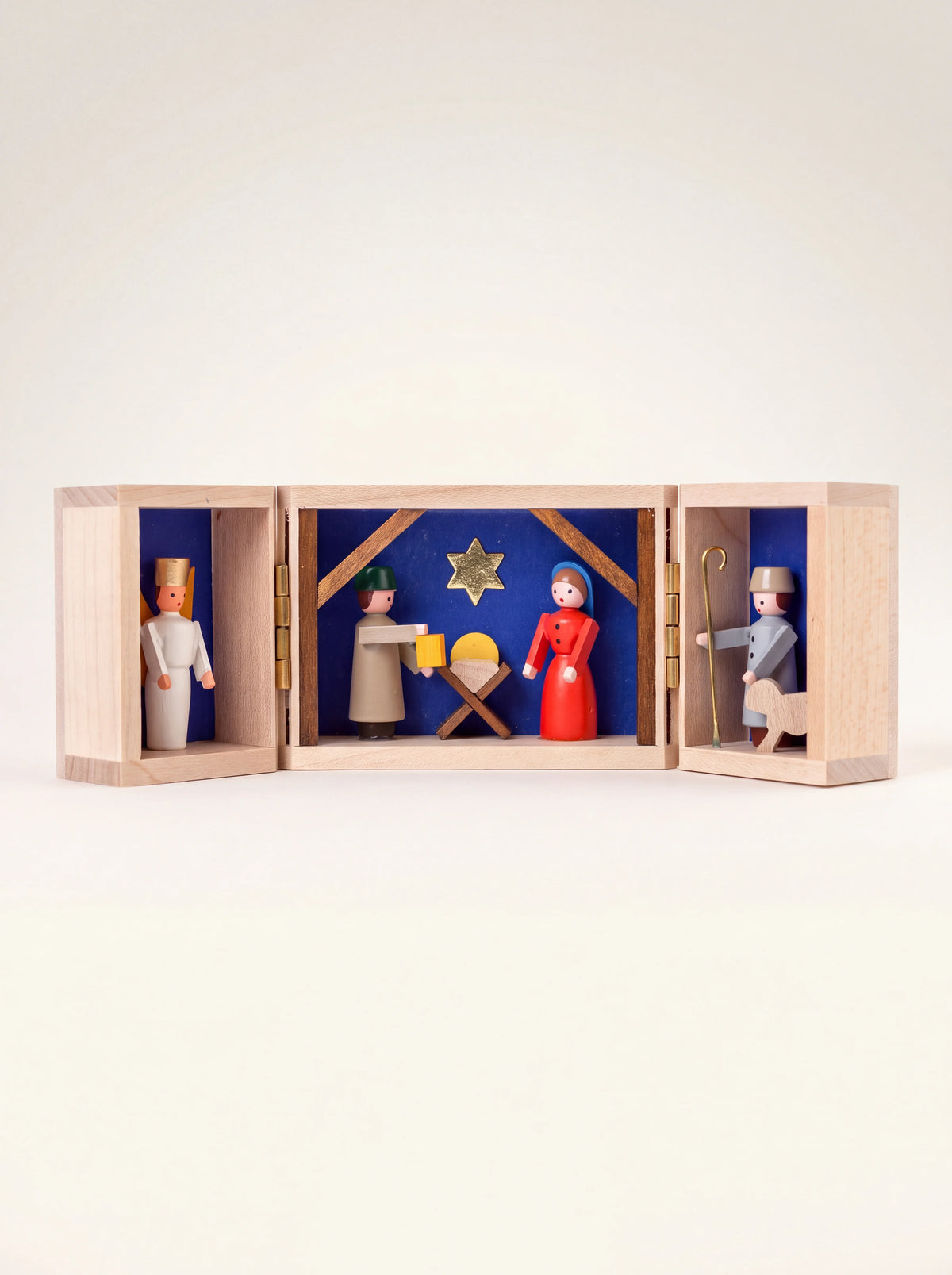 Wooden nativity shrine opened to show painted figures of the Holy Family, an angel and a shepherd