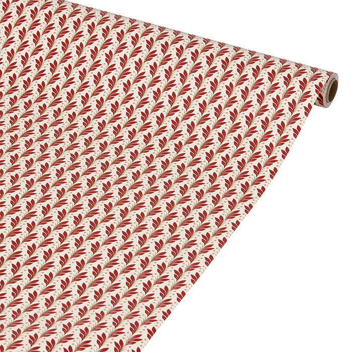 Wrapping paper roll partially unrolled, showing a repeating scarlet foliate pattern on cream paper